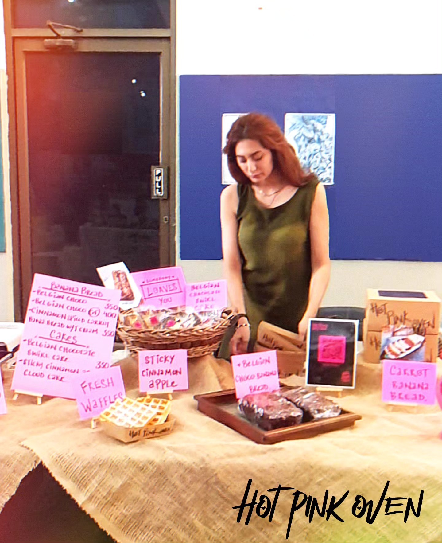 Pop-up table set up under a tree beside the round pink sign